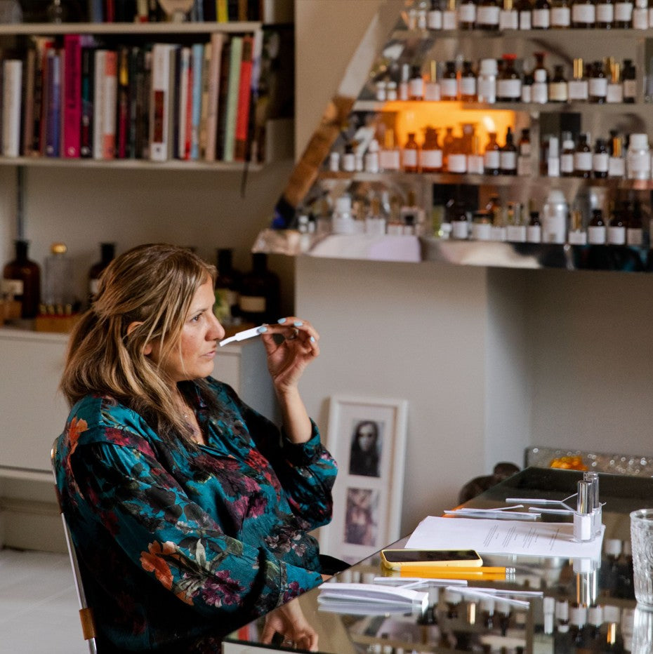Perfume creator testing fragrance notes with a scent strip in the MedEAU formulation lab.