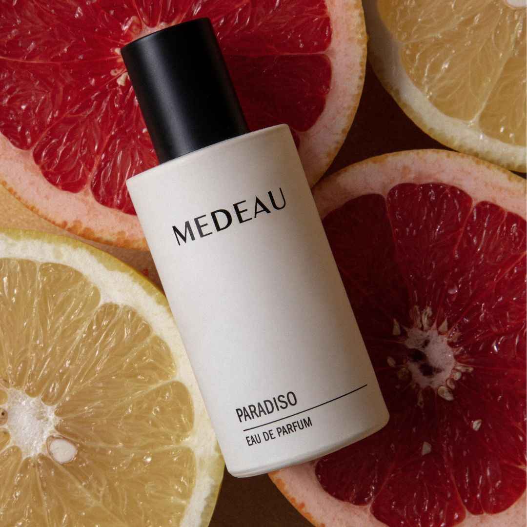 MEDEAU PARADISO EAU DE PARFUM bottle on a background of sliced citrus fruits